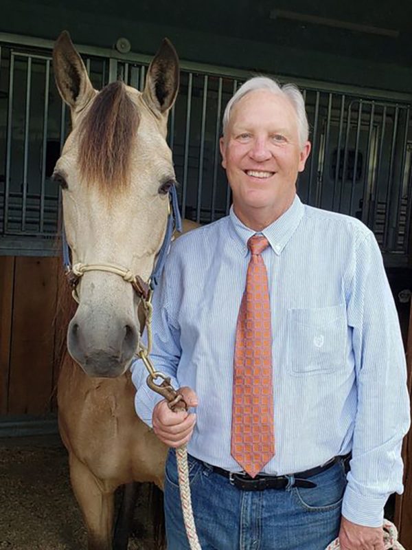 Mark Crisman standing with a horse.