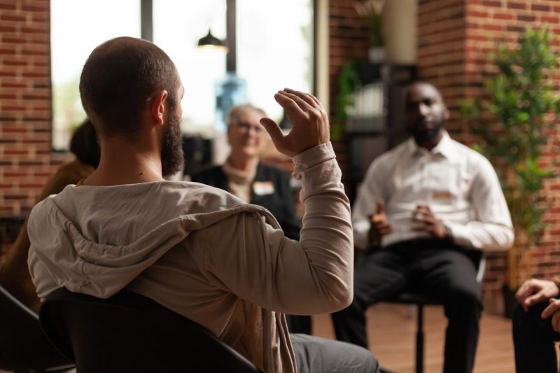 People sitting in a circle talking.
