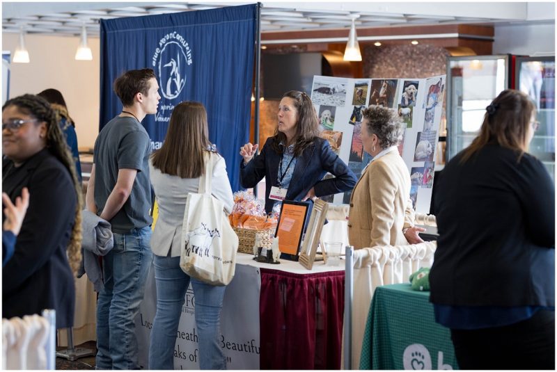 Four people (at center) gathered to hear a person (at center) speak about their business opportunities at the Veterinary Expo